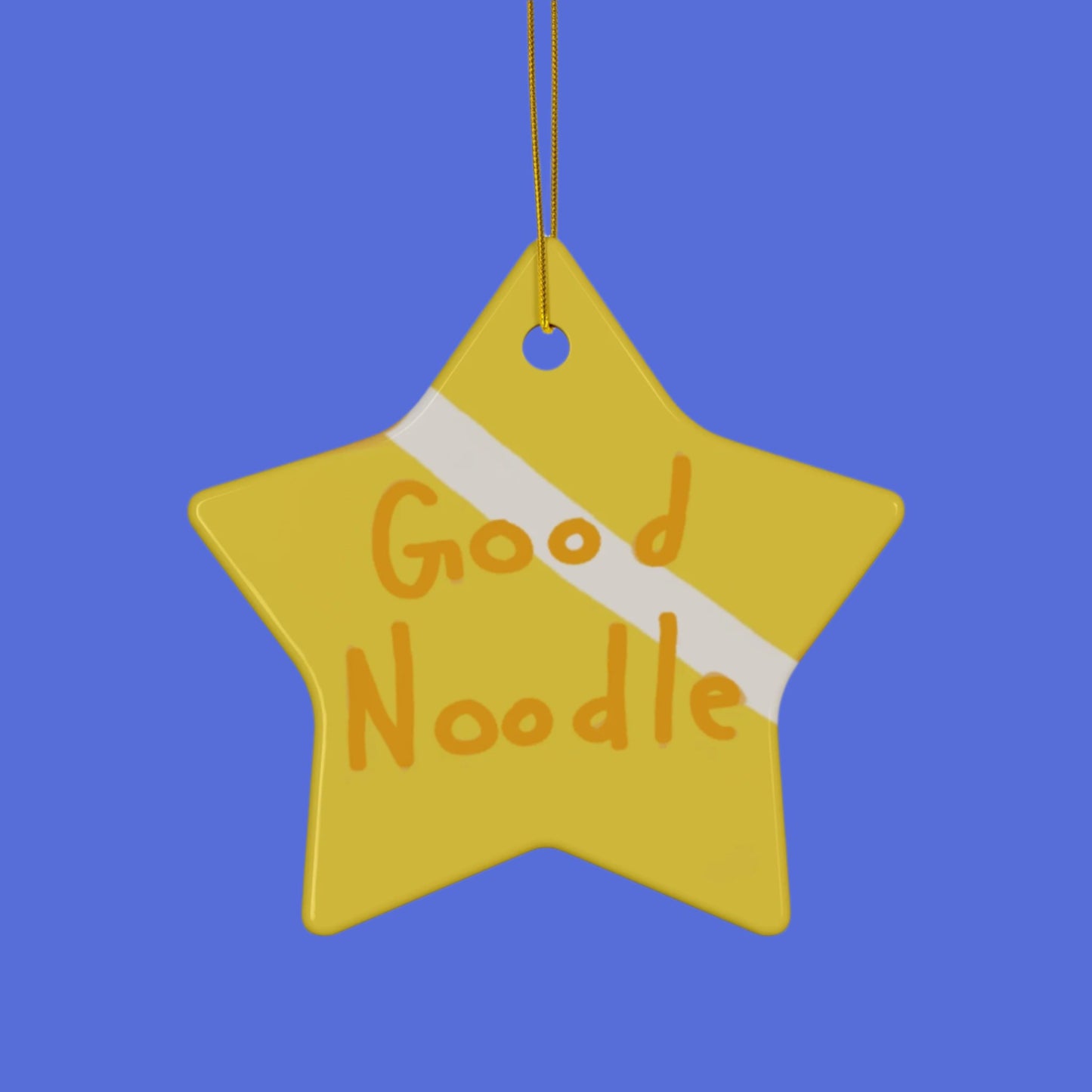 gold star ornament in the style of spongebob that has good noodle displayed across a shiny ceramic surface