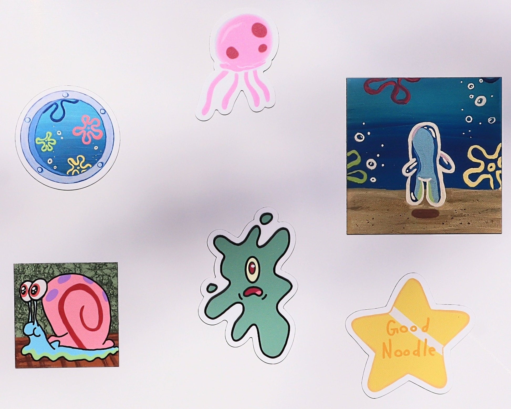 six colorful cartoon magnets on a magnetic whiteboard